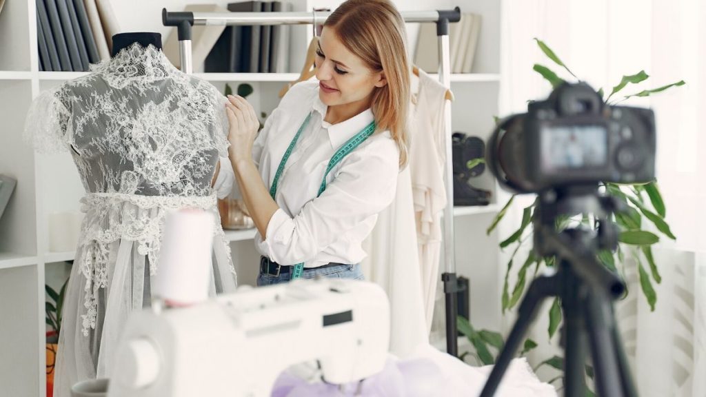 Woman is in a fashion design studio making a video for youtube