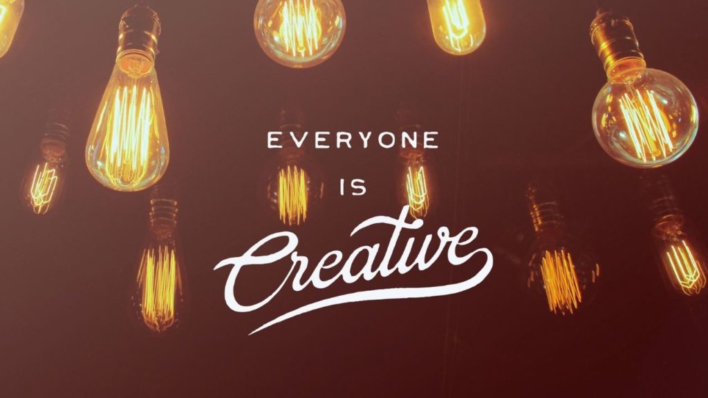 Everyone is Creative quote on a dark background with hanging lightbulbs in different shapes.
