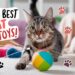 A tabby cat plays with an interactive colorful ball indoors. The room is scattered with various toys and textures. The text reads 10 Best Interactive Cat Toys! accompanied by paw print graphics.