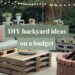 Cozy backyard setup with pallet seating, cushions, and a fire pit. String lights hang overhead, and plants are arranged on cinder blocks. Text overlay reads, DIY Backyard Ideas on a Budget.