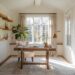 A cozy modern cottage office youll adore with a wooden desk and beige chair, large window with light curtains, potted plant, and wall-mounted wooden shelves. Inspiring minimalist decor and natural light create a soothing atmosphere.