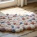 Create a whimsical, budget-friendly cloud-shaped PomPom Rug using pastel yarn and Dollar Store supplies—perfect for brightening any sunlit space.