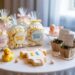 Baby Shower Table Decor Ideas: Popcorn Favors, Rubber Duckies, Onesie Cookies & Plant Gifts for Party Inspiration.