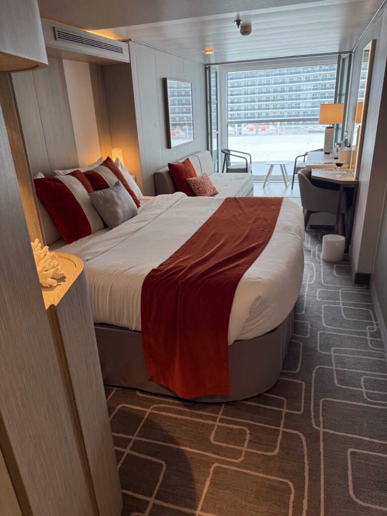 Relax in BC1163EE-680F-42AA-805F-C930A94B5D7C_1_102_o, a chic hotel room featuring bold bedding, a sofa, desk, and snowy vistas.